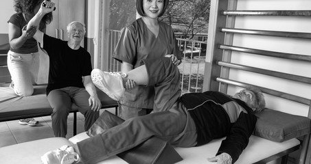 Active elderly people indoor at gym with help of nurses