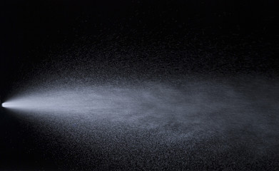 Water jet spraying on black background