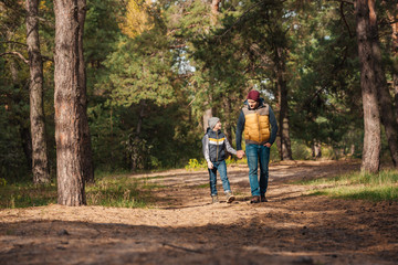 father and son walking in forest