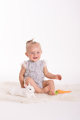 Happy smiling toddler sittting in a studio on a white background 