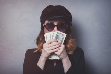 Style redhead girl in black hat and clothes with money