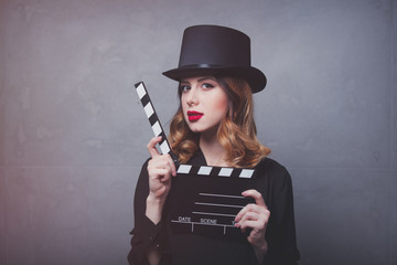 Style redhead girl in top hat with movie clapperboard