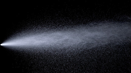 Water jet spraying on black background