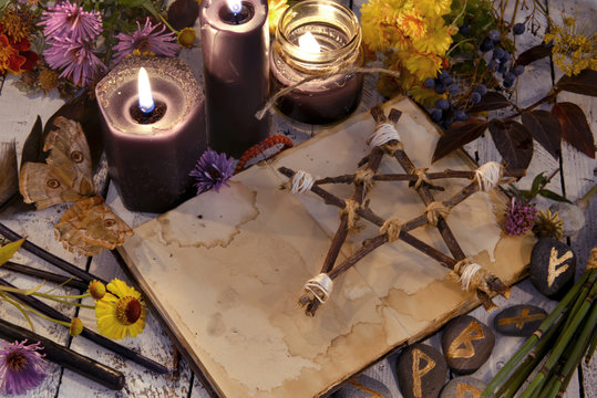 Black candles and pentagram on witch table