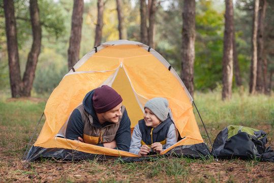 father and son lying in tent