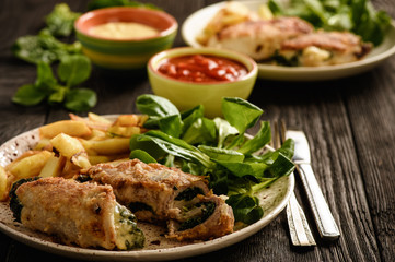 Pork roulades with spinach and cheese filling, served with fried potatoes.