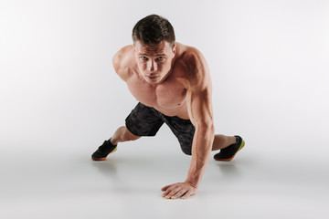 Obraz premium Skoncentrowany młody sportowiec wykonuje ćwiczenia sportowe