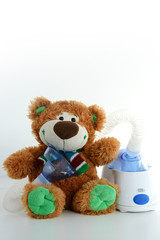 Teddy bear and nebulizer or inhaler, treatment for flu season concept