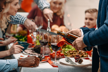 man pouring wine in glasses