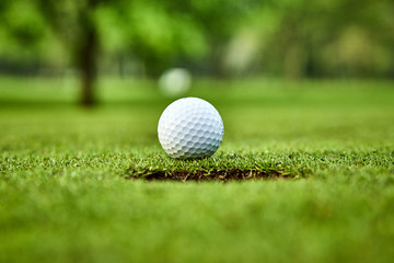 Golf ball on the green. golf ball on lip of cup
