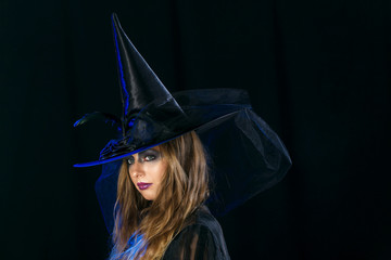 cheerful girl witch on halloween in studio.