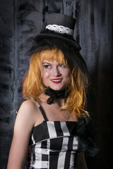 portrait of a girl with red hair, a girl in a hat and a black dress. A dark room, a witch, witchcraft