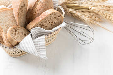 Sliced baguette on basket with Whisk