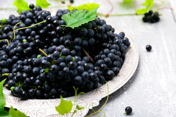 Red wine grapes in silver tray on grey background. Close up.
