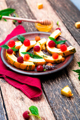 Grilled pumpkin with honey, raspberry and mint on wooden rustic background. Close up.