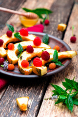 Grilled pumpkin with honey, raspberry and mint on wooden rustic background. Close up.