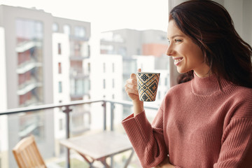 woman drinking morning coffee and looking out the window