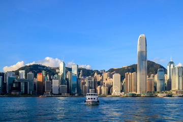 Hong Kong skyline cityscape, modern skyscraper building and ferry transportation traffic at sunrise morning