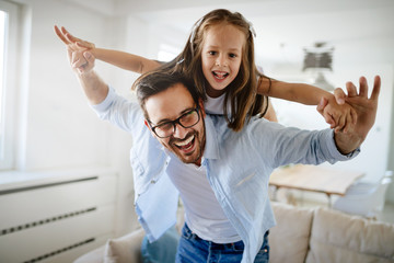 Portrait of father and daughter playing at home