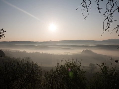 Panoramic timelapse of a landscape of the Tuscan hills during sunrise with fog in the Val d'Orcia