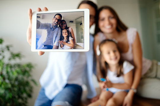 Happy family taking selfie in their house