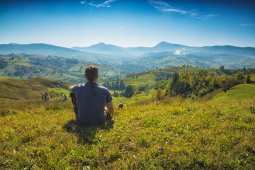 Fototapeta na wymiar Man sitting on a hill in a grass