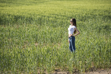 Naklejka na ściany i meble Slim woman pose in profile wear casual clothes standing in green field