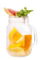 Refreshing drink in a jar mug on a white background. Cocktail with lemon and grapefruit juice and a slice of lemon and grapefruit and mint as a decoration.