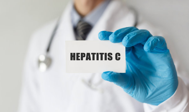 Doctor holding a card with text HEPATITIS C, medical concept