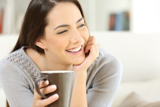 Happy woman holding a cup of coffee