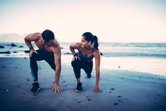 Adult fitness couple doing exercise together on beach