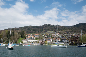 Fototapeta na wymiar Yacht boats float on bay in Lake with mountain in background, Switzerland