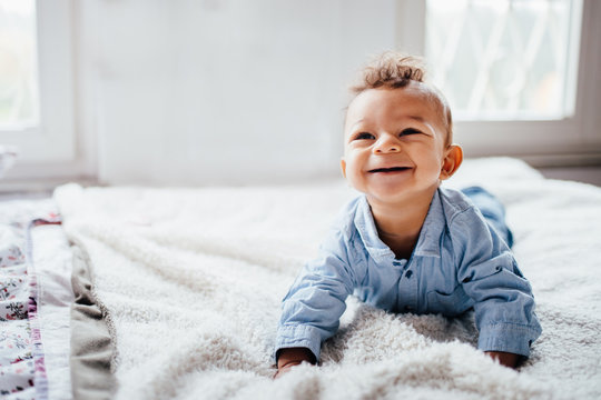 Cute adorable toddler smiling while laying on bed