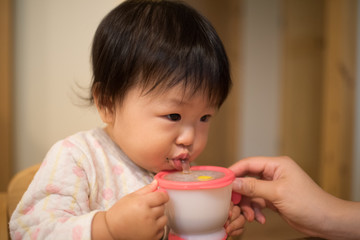 A baby drinking a glass of water with a straw / When you eat a Japanese baby's rice for ten months of age