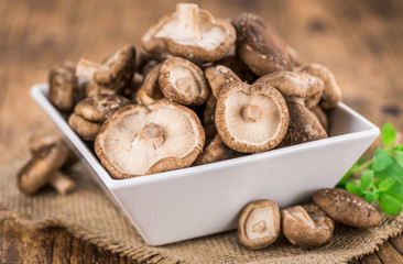Fototapeta premium Wooden table with Shiitake mushrooms, selective focus