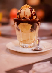 Banana Chocolate, vanilla Ice cream in the cup with a spoon.