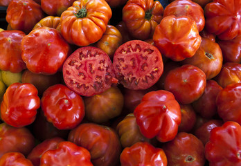 Two halves of juicy ripe tomato in the section. Fresh tomatoes. Red tomatoes. Village market organic tomatoes. Qualitative background from tomatoes.