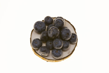 Blueberries on a wooden plate on a white background closeup.Background for confectionery, cafe fresh berries for pastry.