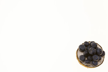 Blueberries on a wooden plate on a white background closeup.Background for confectionery, cafe fresh berries for pastry.