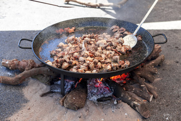 Fried chicken legs. Preparation of chicken paella.national Spanish dish of paella in a large skillet is cooked on an open fire, at the stake