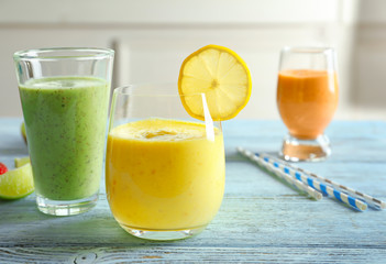 Glasses with yummy smoothie on wooden table