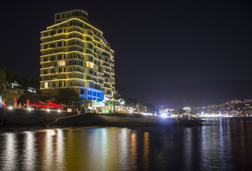 beautiful building on the beach. night landscape, visible reflections in the water