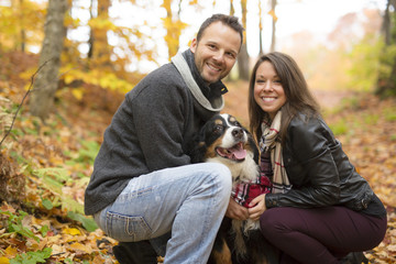 Naklejka na ściany i meble Couple with her Dog in Autumn park. Bernese Mountain Dog