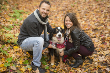 Naklejka na ściany i meble Couple with her Dog in Autumn park. Bernese Mountain Dog