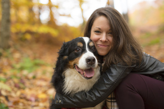 Cute girl with her Dog in Autumn park. Bernese Mountain Dog