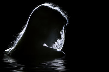 sad woman profile silhouette in dark with reflection on water