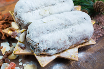 Traditional German Christmas raisins and dried fruits cake with sugar powder and Christmas decorations