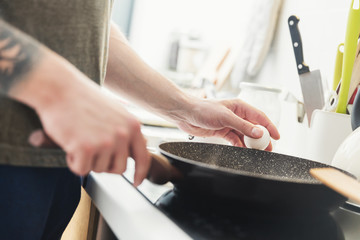 Man preparing fried eggs in the kitchen