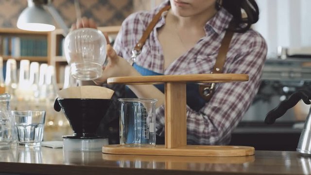 Barista filling up coffee funnel 