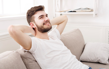 Handsome young man relaxing on couch at home